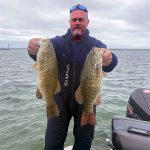 Angler with 2 smallmouth bass img5437